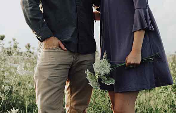 A photo of a man and woman in a flower field